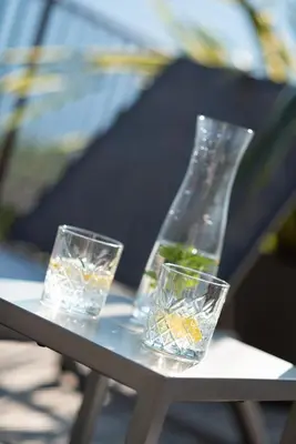 three glasses sitting on a table with a bottle at Hotel und Residence Johanneshof in Cermes