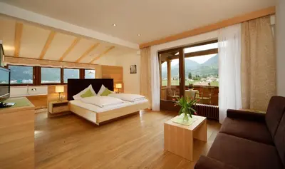a living room with a couch and a large window at Hotel und Residence Johanneshof in Cermes