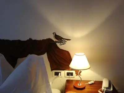 a bird sitting on a branch next to a lamp at Hotel Ca' del Bosco in Selva di Cadore