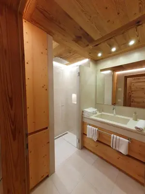a bathroom with a tub and a sink and a mirror at Daniela Apartment in Cortina dʼAmpezzo