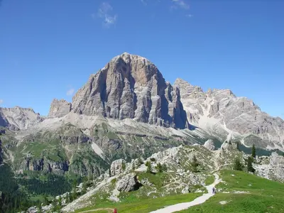 a mountain with a road in front of it at Daniela Apartment in Cortina dʼAmpezzo