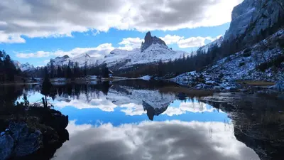 a mountain reflection in a lake in the mountains at Daniela Apartment in Cortina dʼAmpezzo