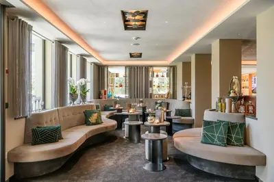 a lobby of a hotel with a couch and tables at FAYN garden retreat hotel in Lagundo