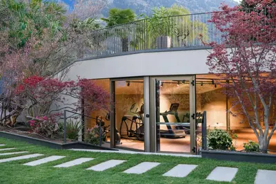 a house with glass doors and a balcony at FAYN garden retreat hotel in Lagundo