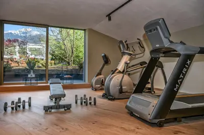a gym with three exercise bikes and a treadmill at FAYN garden retreat hotel in Lagundo