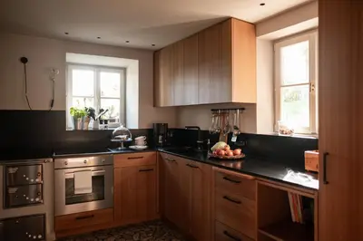 a kitchen with wooden cabinets and a bowl of fruit on the counter at Chalet Hafling Leckplått in Avelengo