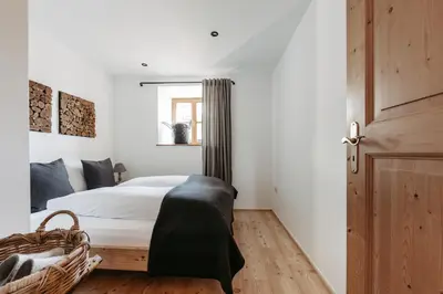 a bedroom with a bed and a window and a door at Chalet Hafling Leckplått in Avelengo