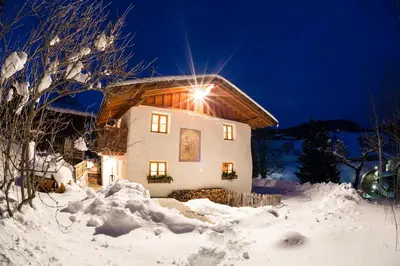a house in the snow at night at Chalet Hafling Leckplått in Avelengo