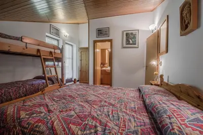 a bedroom with a bed with a wooden ceiling at Appartamento Sellaronda in Arabba