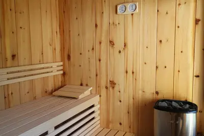 a sauna with a bench and a trash can at Liondes Chalets in San Vigilio Di Marebbe