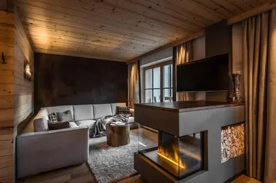 a living room with a fireplace and a couch at Liondes Chalets in San Vigilio Di Marebbe