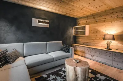 a living room with a couch and a table at Liondes Chalets in San Vigilio Di Marebbe