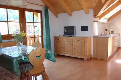 a kitchen with a table and a tv in a room at Oberlindnerhof in San Lorenzo di Sebato