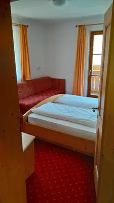 a small bedroom with a bed and a window at Oberlindnerhof in San Lorenzo di Sebato