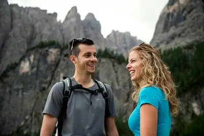 a man and a woman standing in front of a mountain at Residence Mirabell in Colfosco