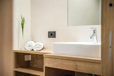 a bathroom with a sink and a mirror and towels at Residence Mirabell in Colfosco