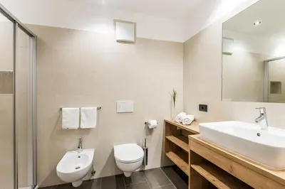 a bathroom with a sink and a toilet and a mirror at Residence Mirabell in Colfosco
