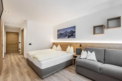 a bedroom with a bed and a couch at Residence Mirabell in Colfosco