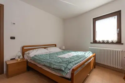 a bedroom with a bed and a window at Villa Simona in Falcade
