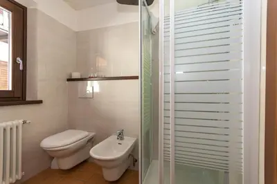 a bathroom with a toilet and a sink and a shower at Villa Simona in Falcade