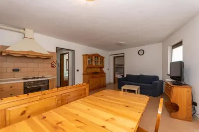 a living room with a wooden table and a couch at Villa Simona in Falcade