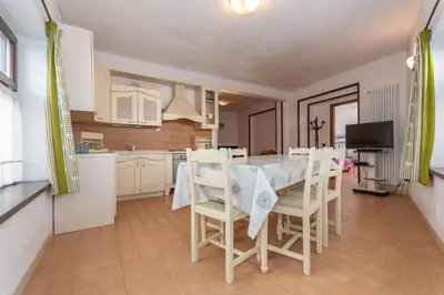 a kitchen and dining room with a table and chairs at Villa Simona in Falcade