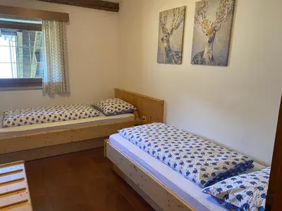 two twin beds in a room with a window at Weishof in Termeno
