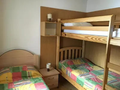 two bunk beds in a small room with a bed at Mes Lastei in Campitello di Fassa