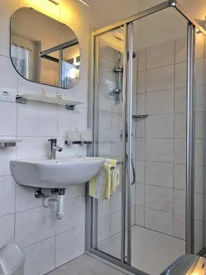a bathroom with a sink and a shower at Pension Planta in Merano