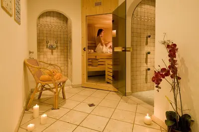 a woman standing in a shower in a bathroom at Pension Appartment Hecherhof in Merano