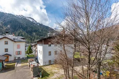 an aerial view of a white building with mountains in the background at Casa Mulaz in Falcade