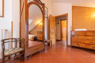 a bedroom with a large mirror and a dresser at Casa Mulaz in Falcade