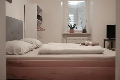 a large bed with white sheets and pillows on it at Chalet 1897 in Caldaro