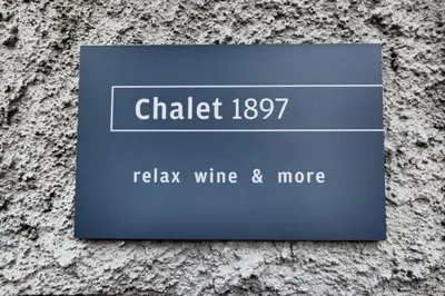a sign on the side of a stone wall at Chalet 1897 in Caldaro