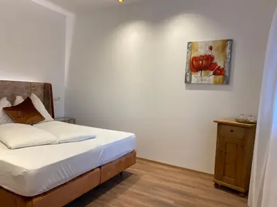 a bedroom with a bed and a painting on the wall at Hotel Garni Vinea Montis in Termeno