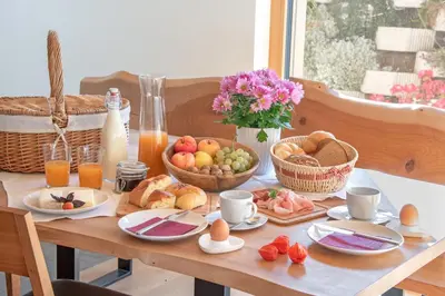 a table with a breakfast of eggs bread and fruit at Turnerhof in Bressanone