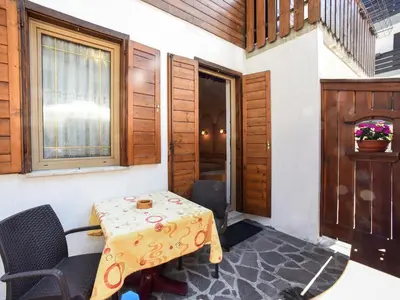a small table and chairs in a room with a window at Hotel Adriana in Alleghe