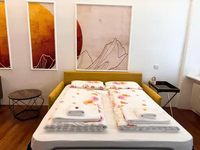 a bed with pillows on it in a room at Atelier La Stube - Alpine Design Home in Bolzano