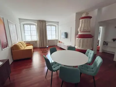 a living room with a table and a wedding cake at Atelier La Stube - Alpine Design Home in Bolzano