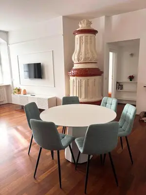 a dining room with a table and chairs and a tv at Atelier La Stube - Alpine Design Home in Bolzano