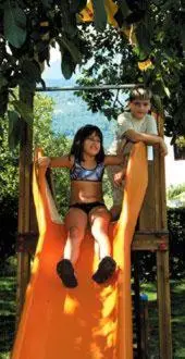 a girl and a boy riding on an orange slide at Hotel Laurin in Lagundo