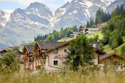 a village in the mountains with mountains in the background at Hotel Rosenheim in Racines