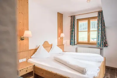 a bedroom with a bed and a window at Hotel Rosenheim in Racines