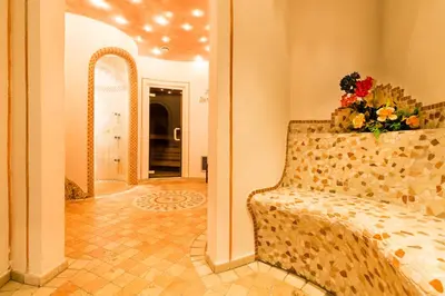 a living room with a couch with a bouquet of flowers at Hotel Rosenheim in Racines