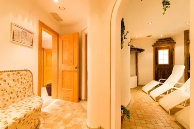 a living room with white chairs and a couch at Hotel Rosenheim in Racines
