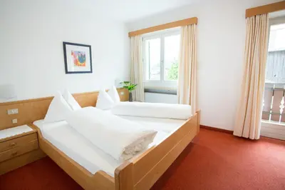 a bedroom with two beds and a window at Garni Pluner in Schenna