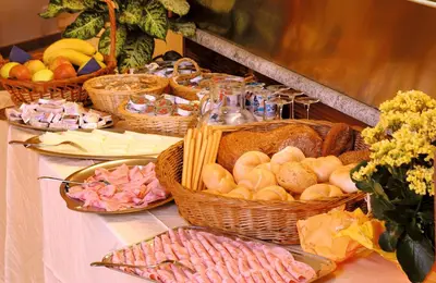 a buffet with baskets of food on a table at Garni Pluner in Schenna