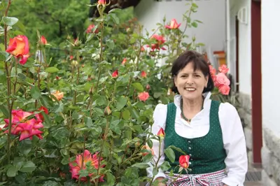 a woman standing in front of a garden of roses at Garni Pluner in Schenna