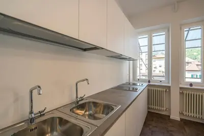 a kitchen with stainless steel sinks and a window at Stay COOPER l Capitol Rooms in Bolzano