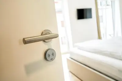 a door with a handle next to a bed at Stay COOPER l Capitol Rooms in Bolzano